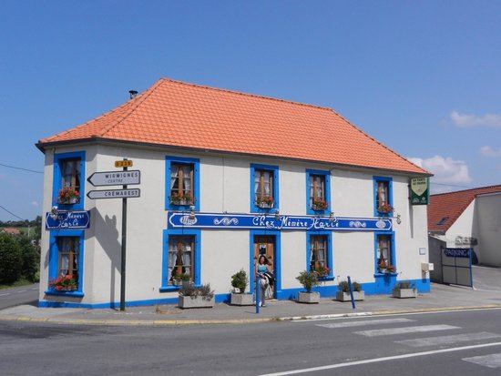 Façade crépie aux volets bleus de la ferme-auberge Chez Mémère Harlé, à Wirwignes